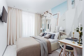 A modern hotel room with a bed, a desk with a chair, a TV, and a large window with curtains. - VISIONAPARTMENTS Vevey Rue des Communaux (Vevey)