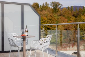 A balcony with a table, two chairs, a bottle of wine, and glasses. - VISIONAPARTMENTS Vevey Rue des Communaux (Vevey)