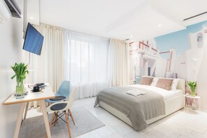 A modern hotel room with a bed, a desk with a chair, a TV, and a window with curtains. - VISIONAPARTMENTS Zug Baarerstrasse (Zug)