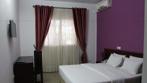 Una habitación de hotel con una cama, un escritorio y una silla.