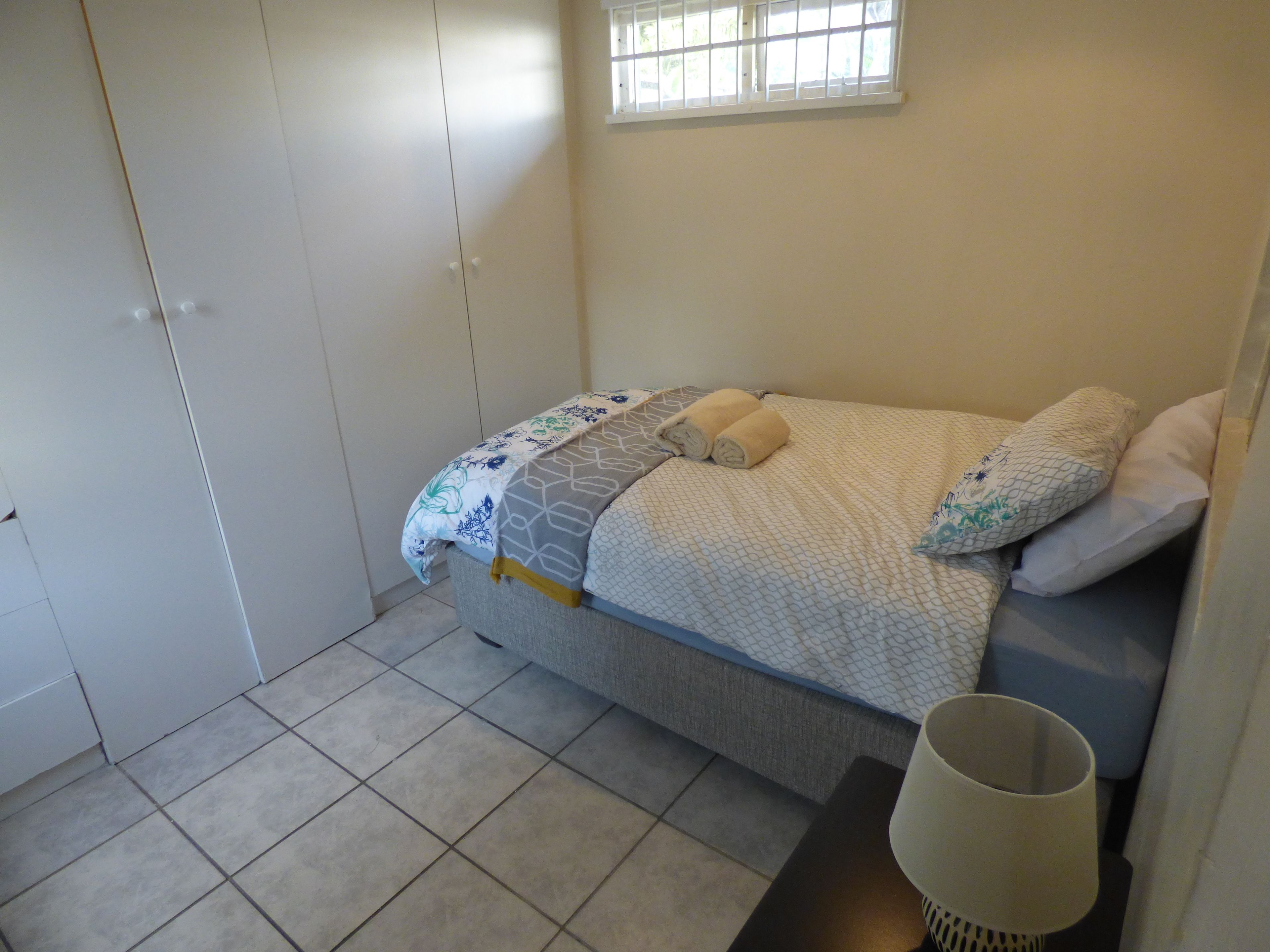 Un dormitorio con cama, ventana y puerta.