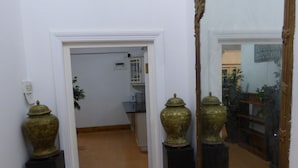 A hallway with a large mirror and two ornate vases on pedestals. - Daisy Lodge (Durban)