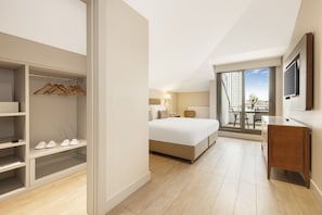 A hotel room with a bed, a desk, a wardrobe, and a balcony with a view. - Tzl Suites (Istanbul)