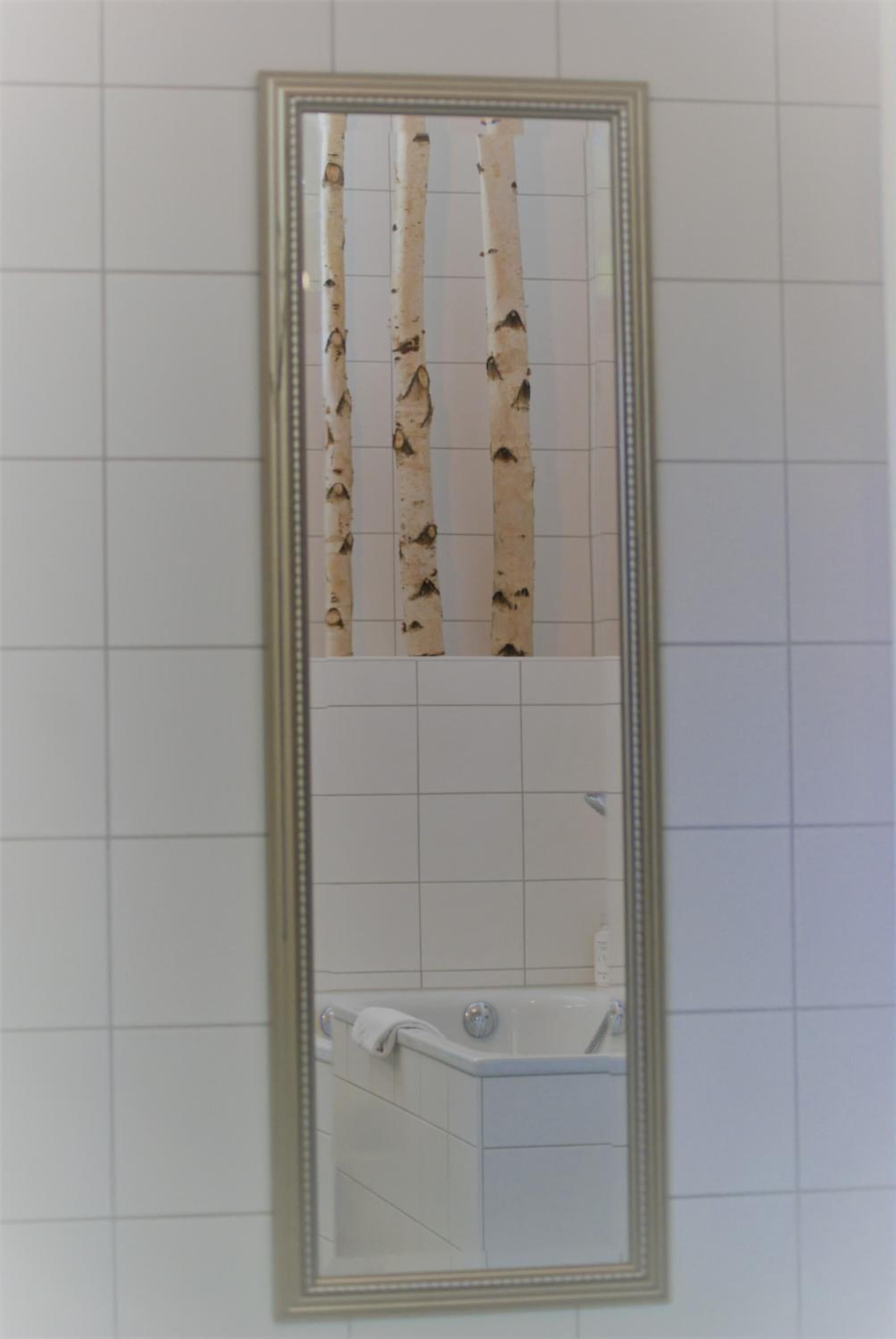 Ein Badezimmer mit Spiegel, Badewanne und Toilette.