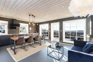 Una cocina moderna con comedor, ventanas amplias y vistas al exterior.