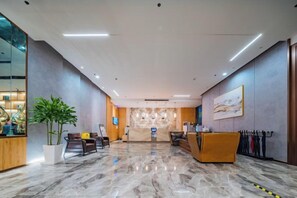 A hotel lobby with a reception desk, seating area, and a large potted plant. - TOWO Shangpin Hotel (Xi'an Bell Tower Metro North Street Branch) (Xi'an)