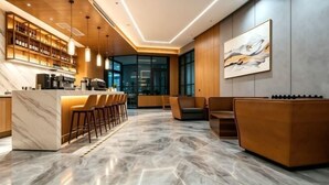 Un espacio moderno de bar con suelo de mármol, barra de madera y asientos.