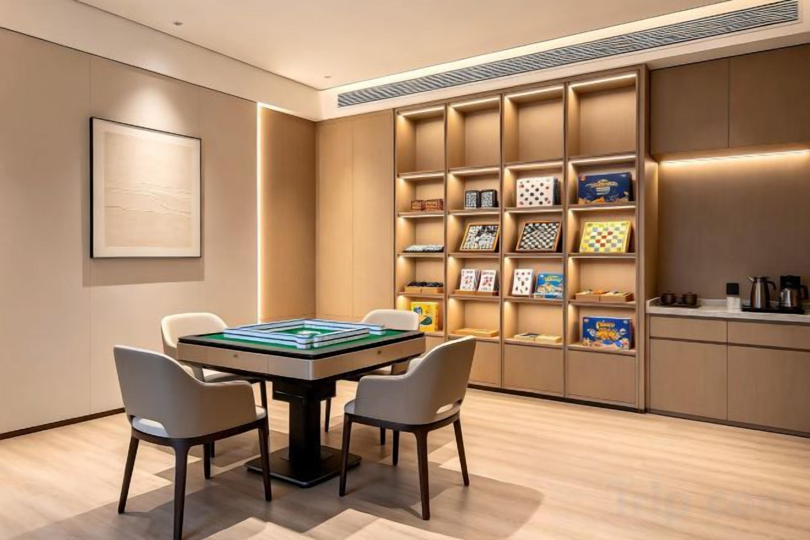 A room with a table and chairs, a bookshelf, and a framed picture on the wall.