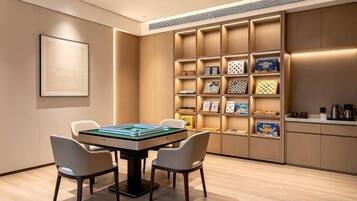 A room with a table and chairs, a bookshelf, and a framed picture on the wall.
