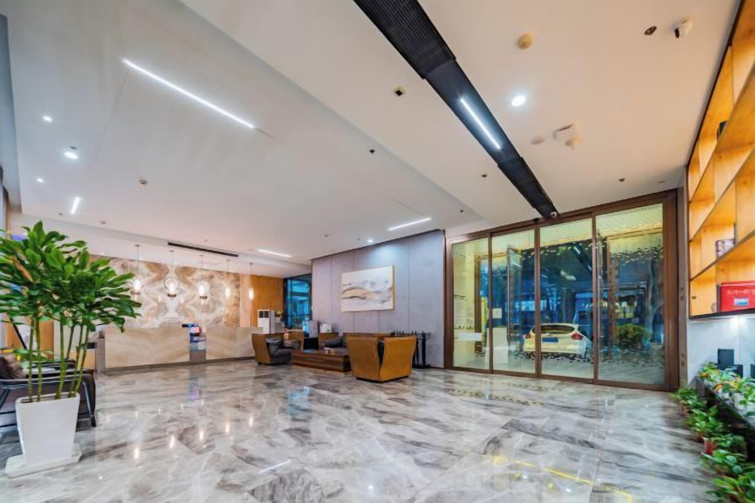 Recepció d'un hotel modern, amb escriptori, zona de seients i una gran porta de vidre que fa a l'exterior.