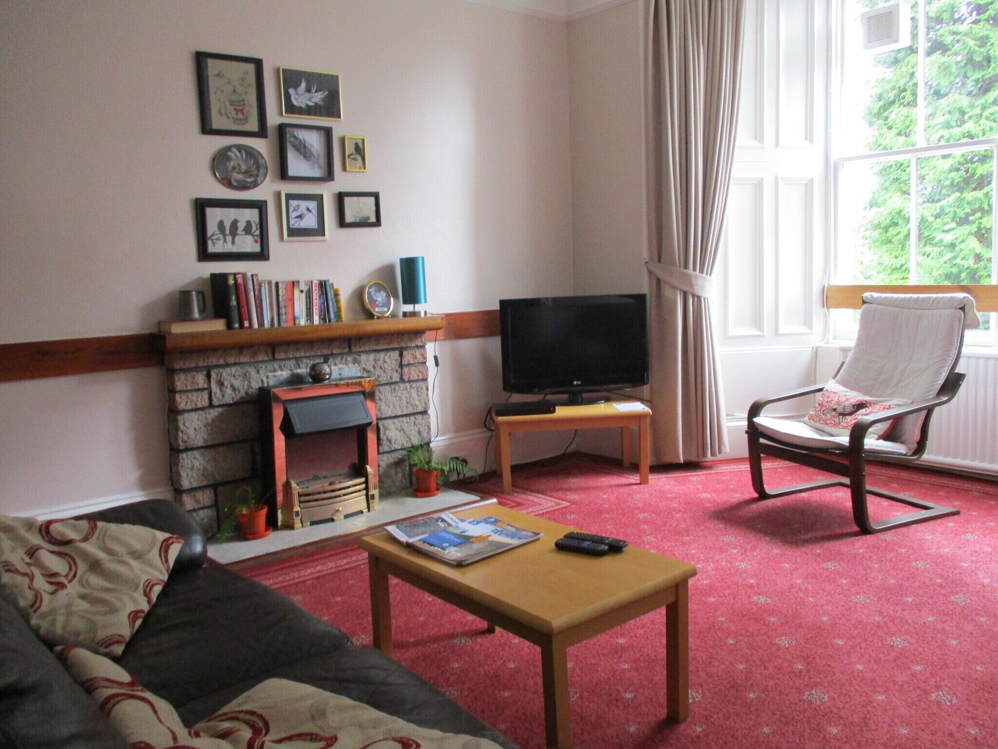 A living room with a fireplace, a television, a rocking chair, and a sofa.