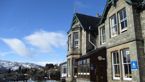 A stone building with a traditional design, featuring large windows and a prominent entrance. - Pitlochry Youth Hostel (Pitlochry)
