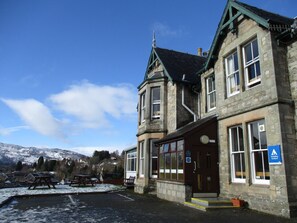 A stone building with a traditional design, featuring large windows and a prominent entrance. - Pitlochry Youth Hostel (Pitlochry)