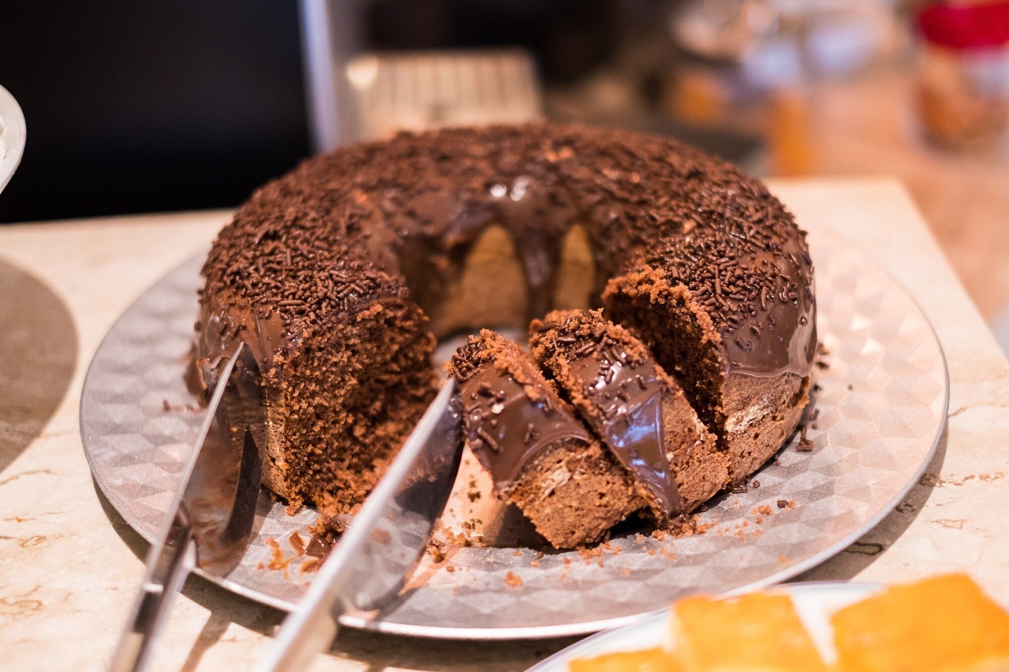 Un gâteau au chocolat décoré de vermicelles, présenté sur une assiette.