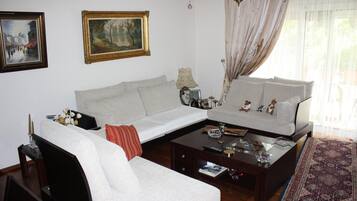 Una sala de estar con sofá, sillones, una mesa de centro y alfombra.