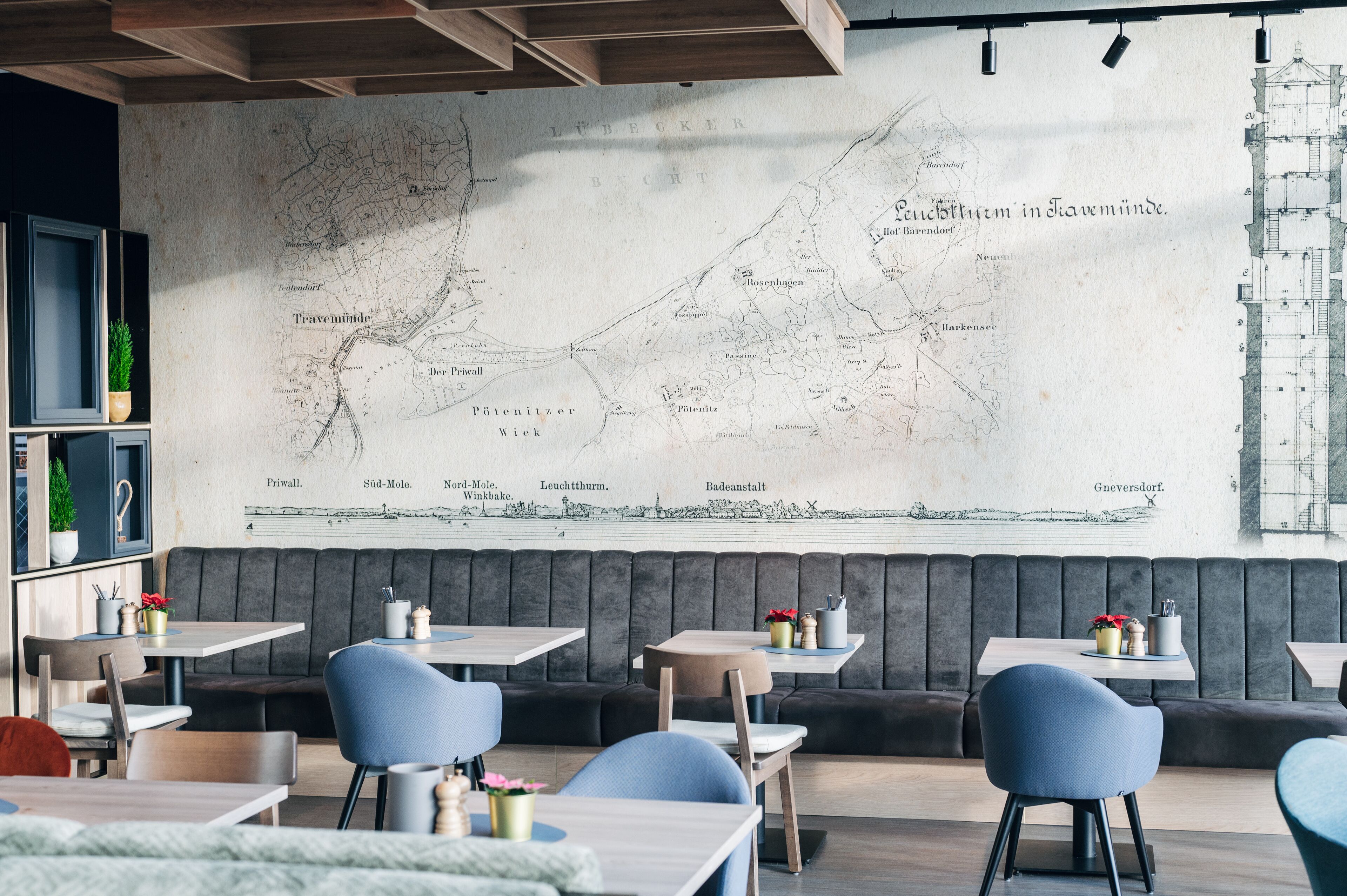 L’intérieur d’un restaurant, avec une grande carte accrochée au mur, des tables, des chaises et une bibliothèque.