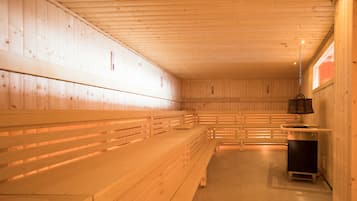Una sauna con bancos de madera y un calentador.