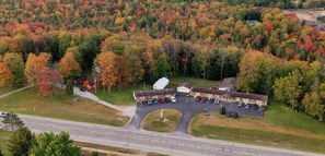 An aerial view of a motel with a parking lot and a road in front. - Alger Falls Motel (Munising)