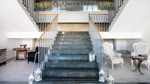 A grand staircase with a sign reading "Queen Daisy Hotel" leading to an upper floor. - Hotel Queen Daisy (Castellammare di Stabia)