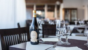 A table set with a bottle of Amarone wine, empty wine glasses, and a fork. - Hotel Queen Daisy (Castellammare di Stabia)