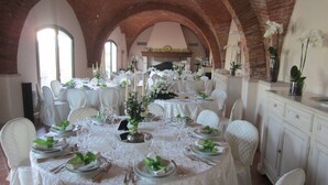 A banquet hall with round tables set for a formal event, featuring white tablecloths, chairs, and floral centerpieces. - Le Colombaie Country Resort (Ponsacco)