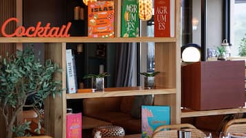 A cozy bar area with wooden shelves, hanging lamps, and wicker furniture.