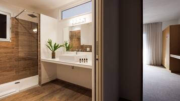 A modern bathroom with a shower, a sink, and a mirror.