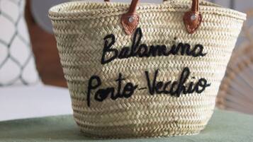 A woven basket with handles and text, placed on a green surface.