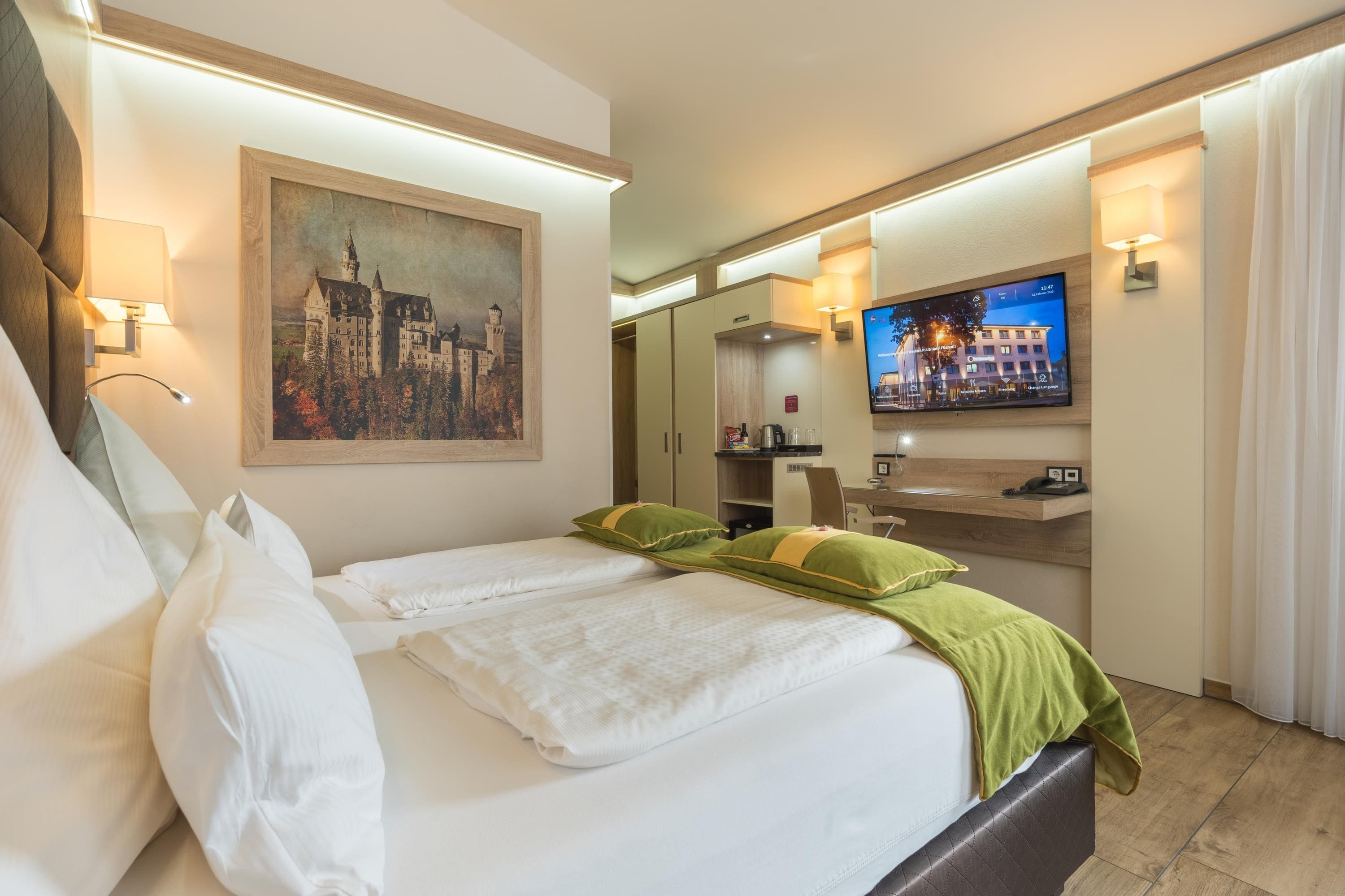 Una habitación de hotel con cama, un cuadro, televisor y baño.