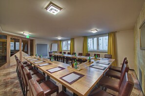Une salle de conférence avec une longue table, des chaises et un tableau blanc.