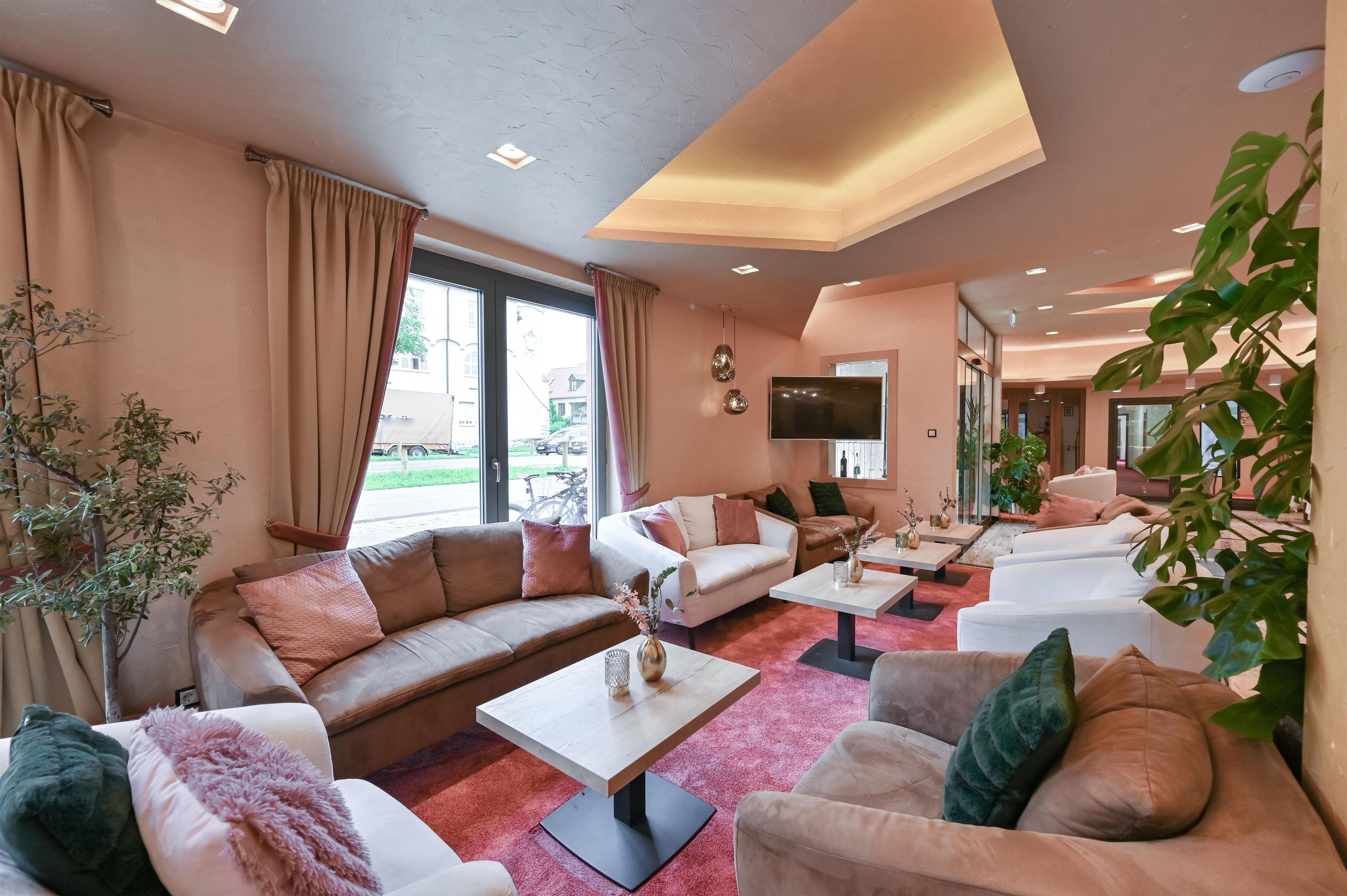 A modern living room with a sofa, armchairs, a coffee table, and a TV.