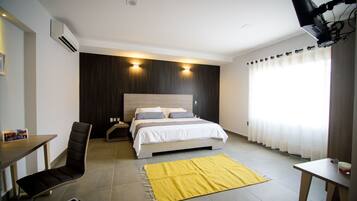 Una habitación de hotel moderna con una cama, un escritorio y una silla.