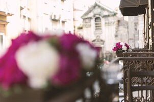 Un balcone con ringhiera e un vaso di fiori.