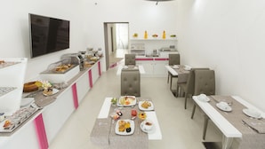 Un comedor moderno con barra de buffet, un televisor de pantalla plana y un diseño limpio y minimalista.