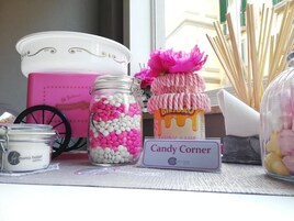 Un espositore di barattoli di caramelle e un cartello con la scritta 'Candy Corner' in un hotel.