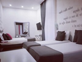 Camera d'albergo con due letti, una scrivania, una sedia e una televisione.