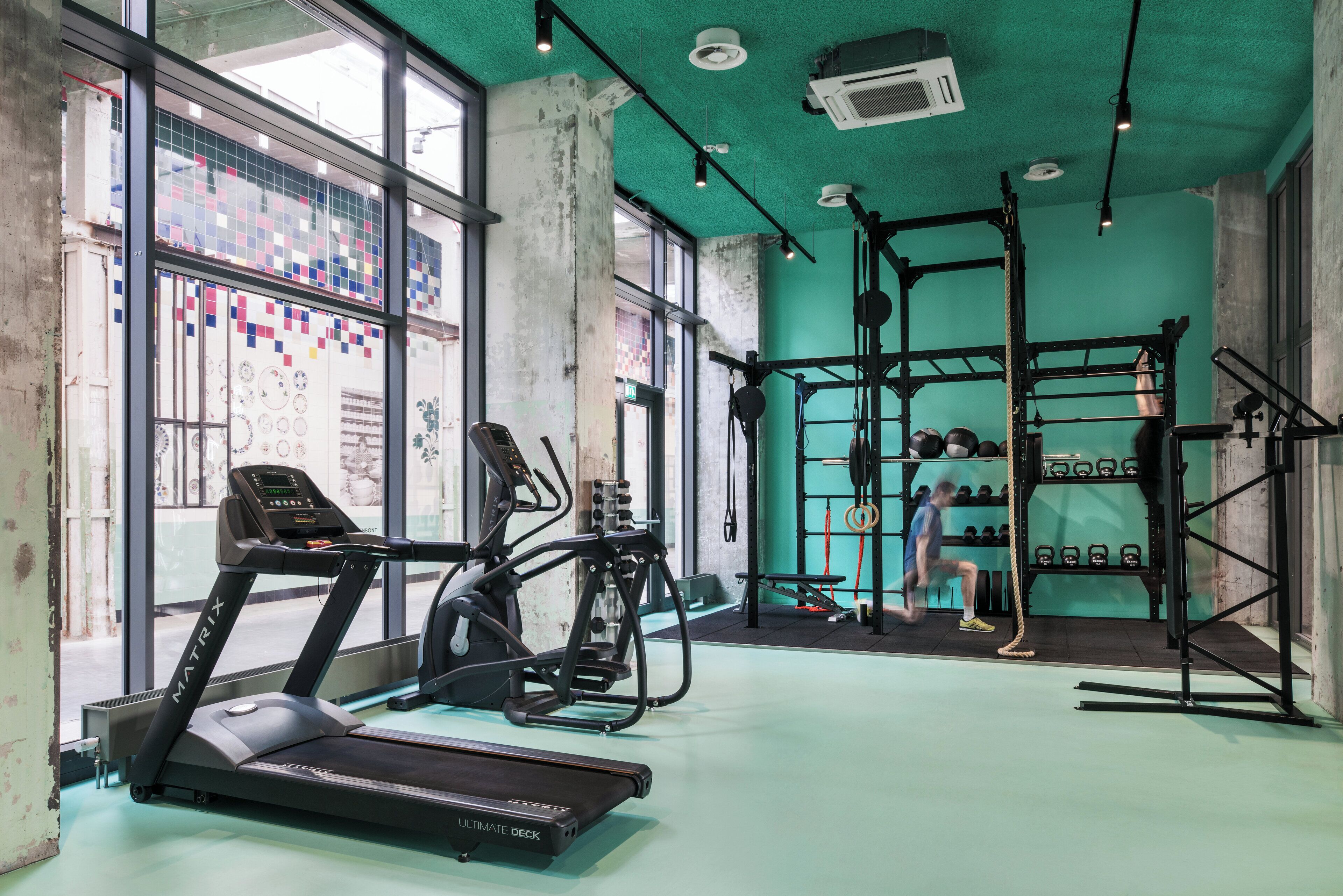 A gym with treadmills, weight machines, and a squat rack.