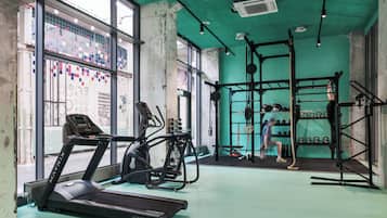 A gym with treadmills, weight machines, and a squat rack.