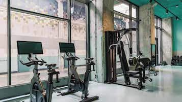 A gym with stationary bikes, a weight machine, and a treadmill.