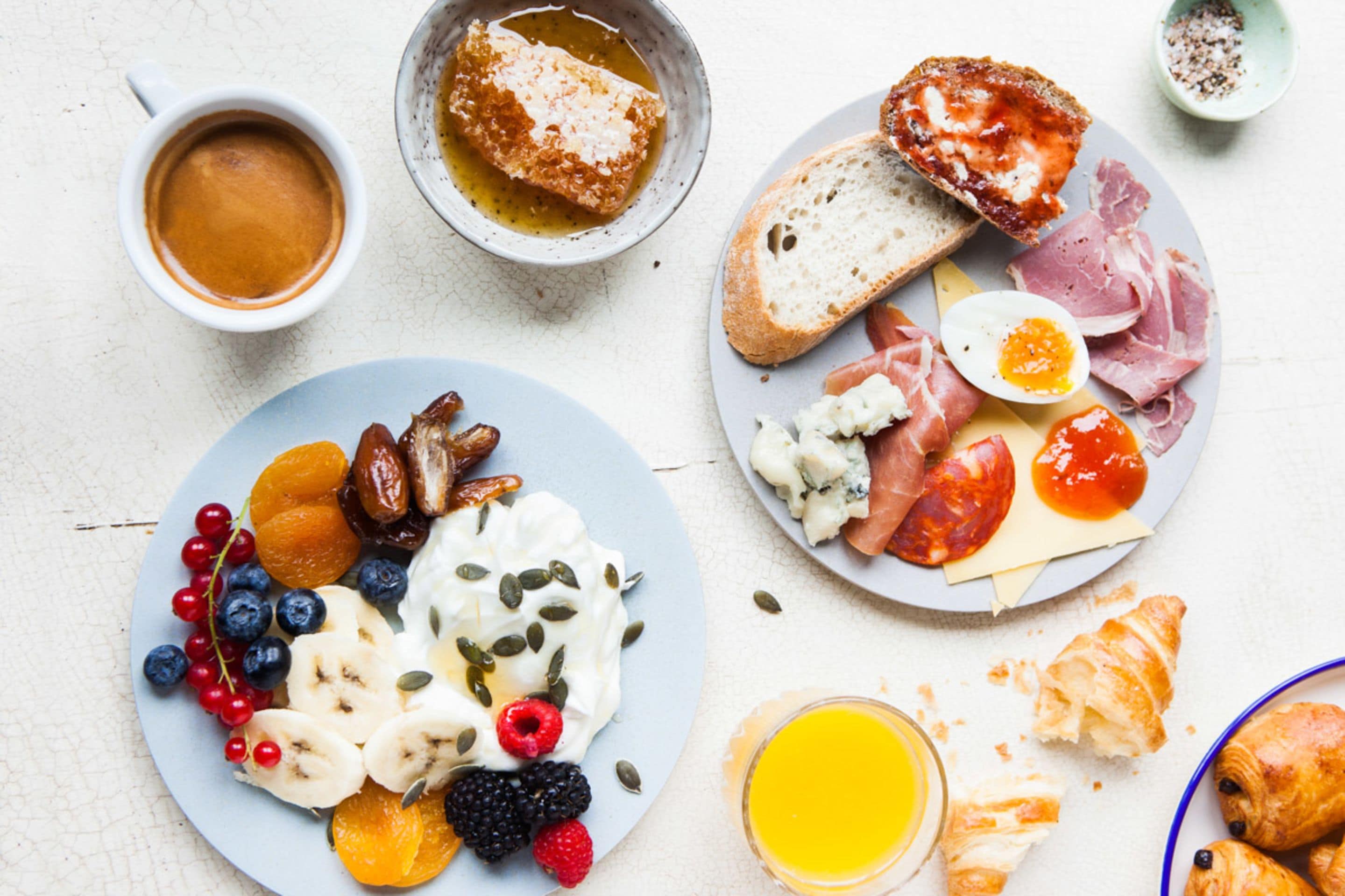 Una mesa con una variedad de alimentos y bebidas para el desayuno.