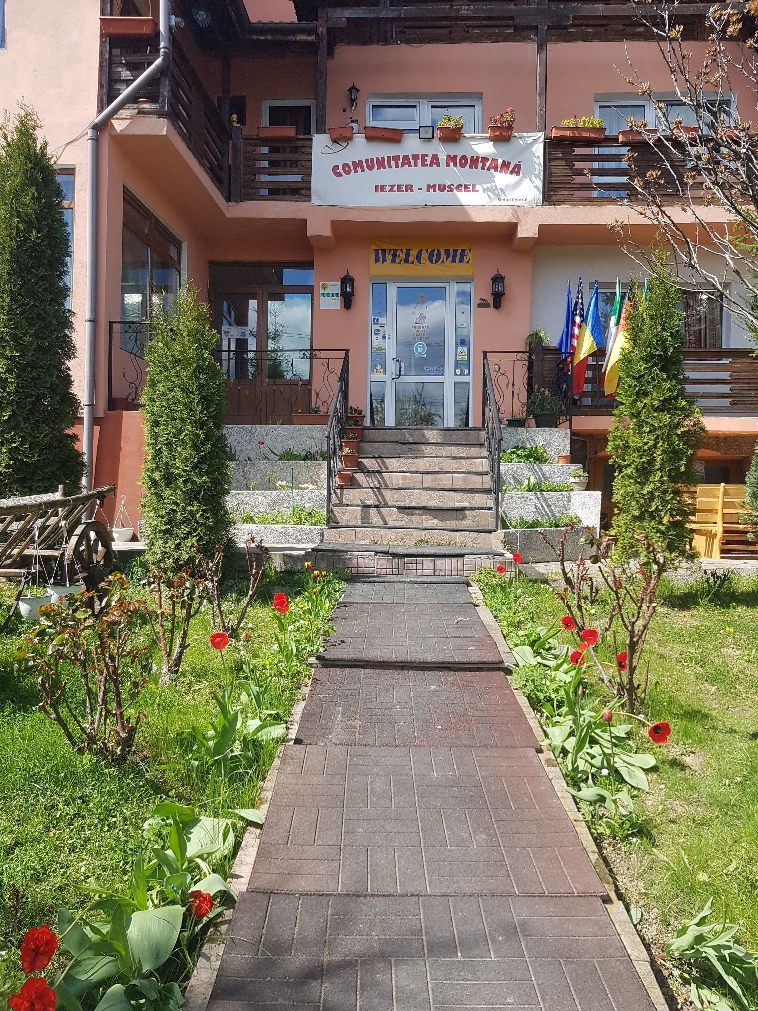 A building with a sign reading "COMUNITATEA MONTANA" and "WELCOME".