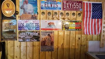 A wall with various travel-themed signs, including Nevada Elvis, Los Angeles, Hollywood, and a Belgian sign.