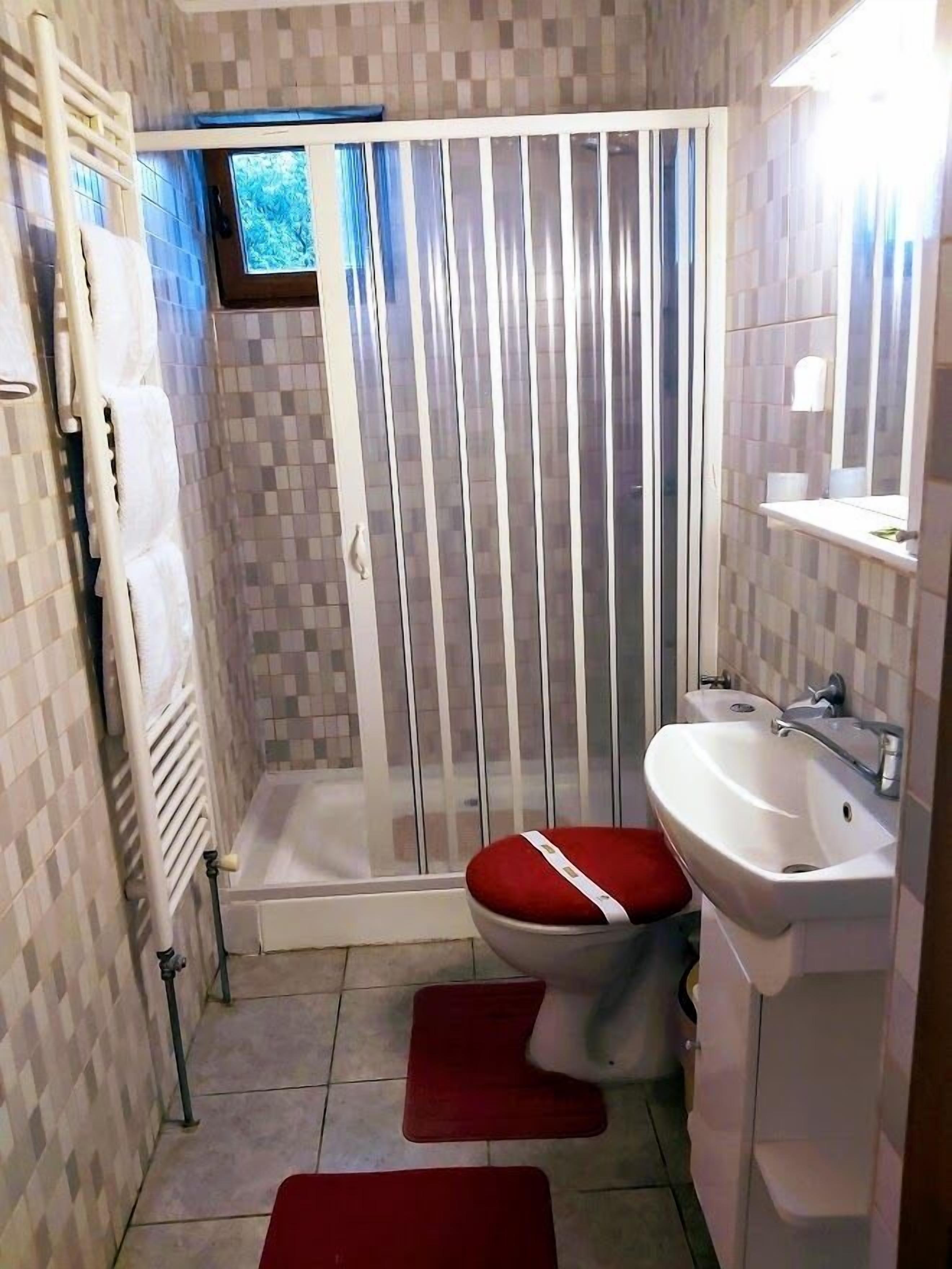 Un baño con ducha, inodoro y lavabo.