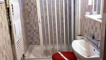 Un baño con ducha, inodoro y lavabo.