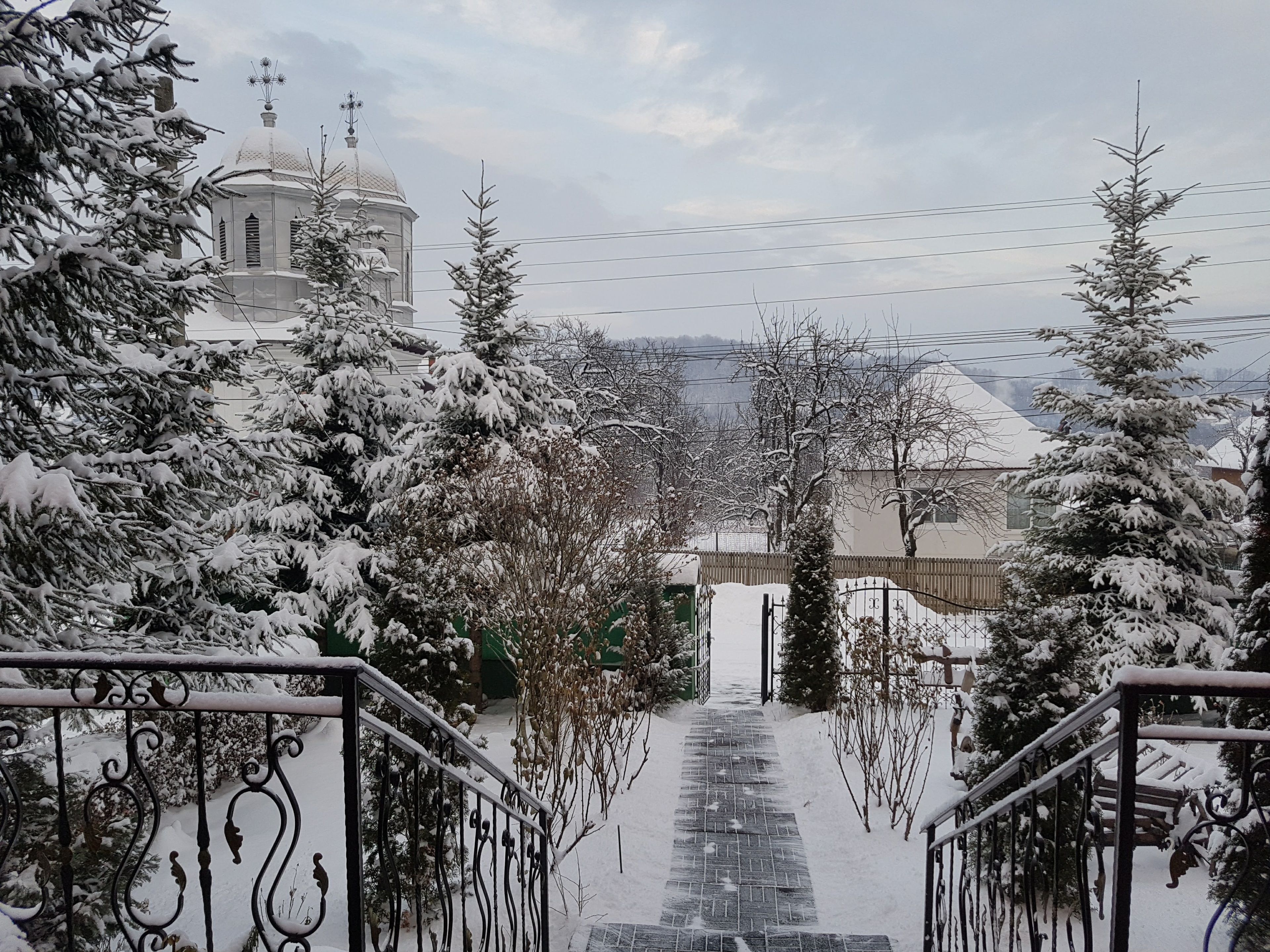 A snowy landscape with a church and a staircase leading up to a building.