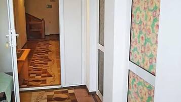 Um corredor com carpete xadrez, uma porta com padrão floral e uma placa indicando o quarto 107.