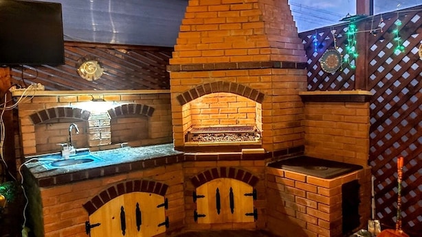 A brick-built kitchen with a built-in oven, a sink, and a wooden counter. - Pensiunea Agroturistica Piscul Soarelui (Godeni)