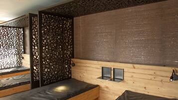 Relax in a serene space with a wooden slatted wall, wall-mounted lights, and a cozy bench.
