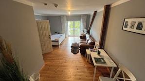 Una habitación acogedora con una cama, un sofá, una mesita y una silla.