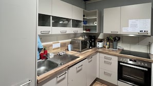 Una cocina moderna con electrodomésticos de acero inoxidable, un lavamanos y armarios.